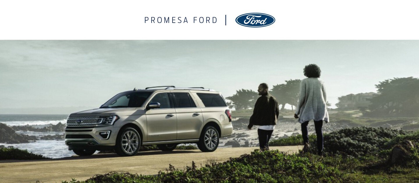 Promesa Ford. Una pareja caminando hacia una Ford Expedition estacionada en una playa
