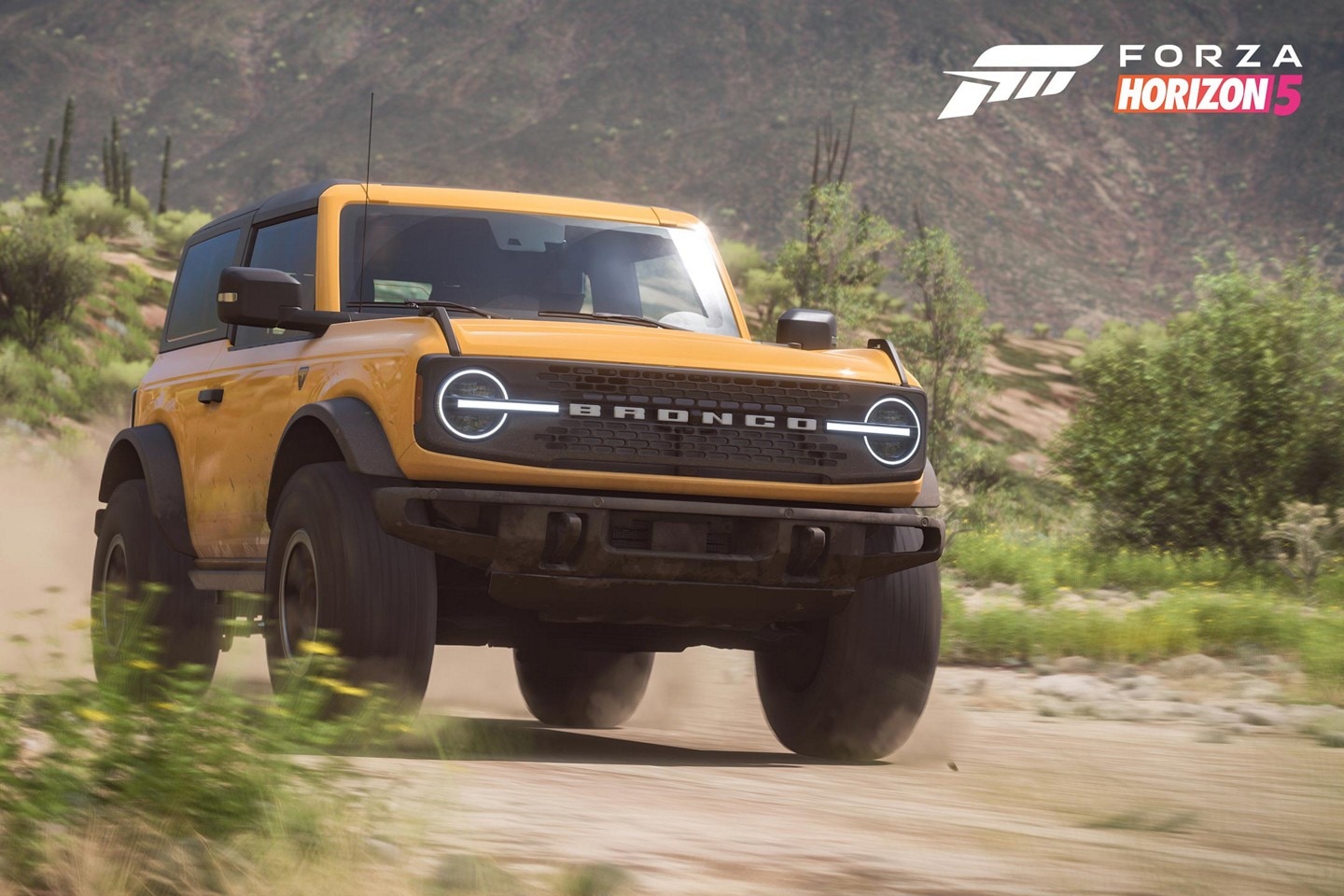Una Ford Bronco™ Badlands™ amarillo pasando por un camino desierto en el videojuego Forza Horizon 5