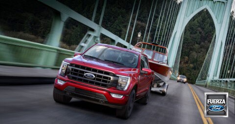 Una Ford F Ciento Cincuenta 2021 remolcando un bote en un puente