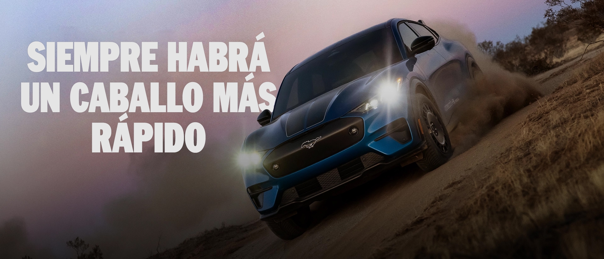Un SUV Ford Mustang Mach-E® Rally andando por la tierra con árboles de fondo