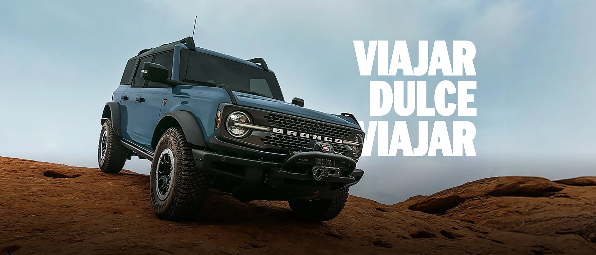 Una SUV Ford Bronco® Badlands® estacionada triunfante en la cima de una gran formación rocosa