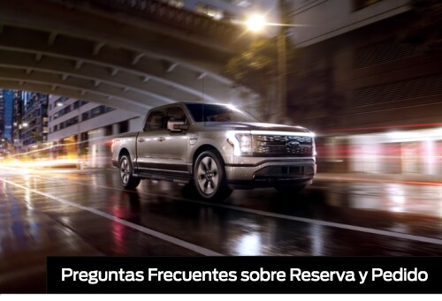 Reservation FAQ. An F-150 Lightning drives down a street at night.