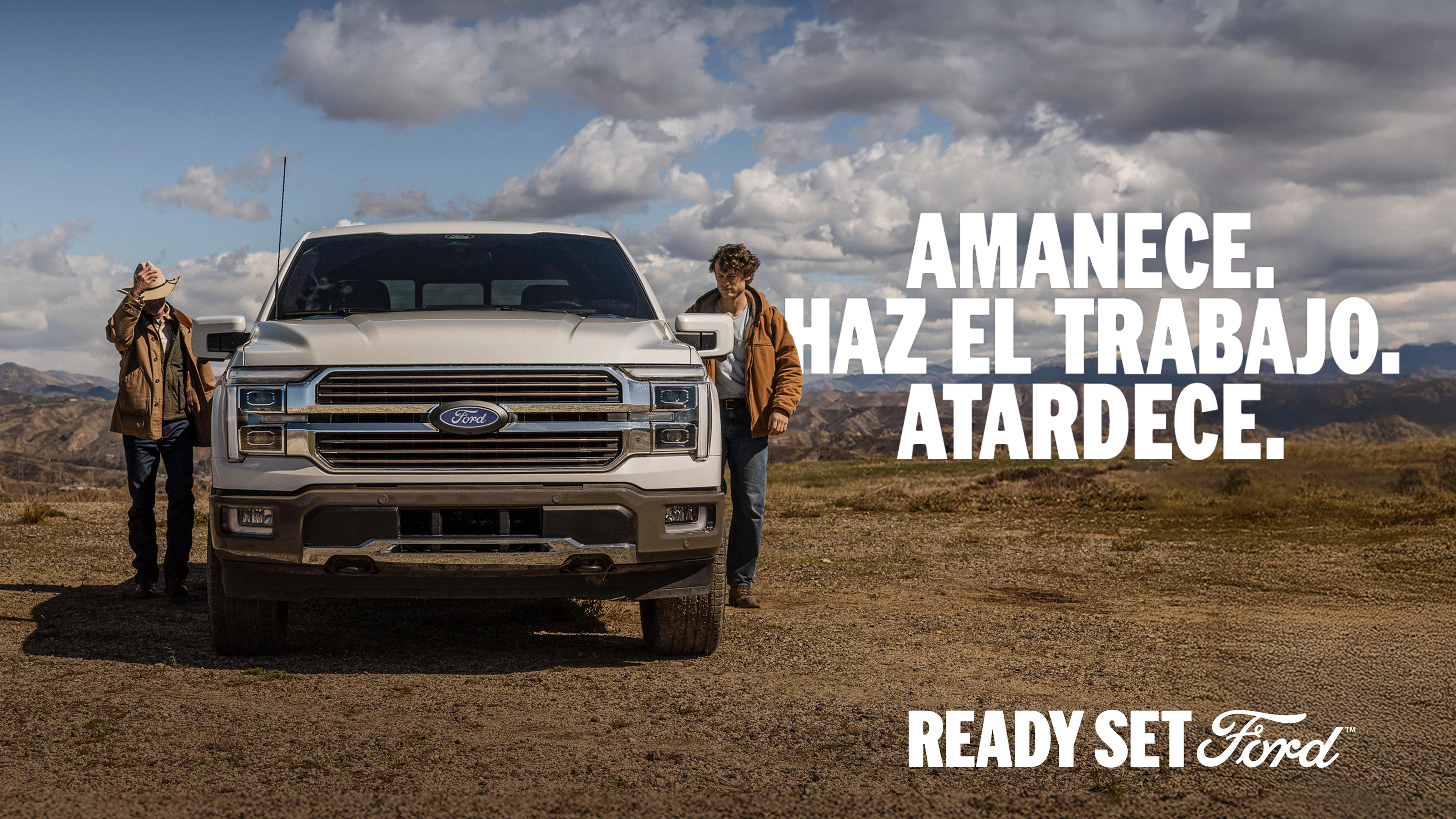 Ford F-150® King Ranch® 2025 estacionada en un campo al lado de dos manos de rancho