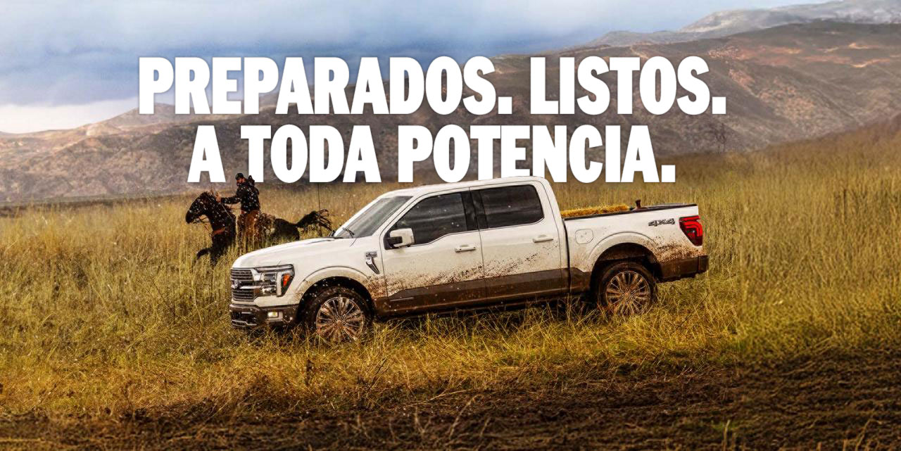 Un modelo Ford F-150® King Ranch® 2025 en White andando por un campo al lado de un hombre en caballo con una cadena montañosa de fondo
