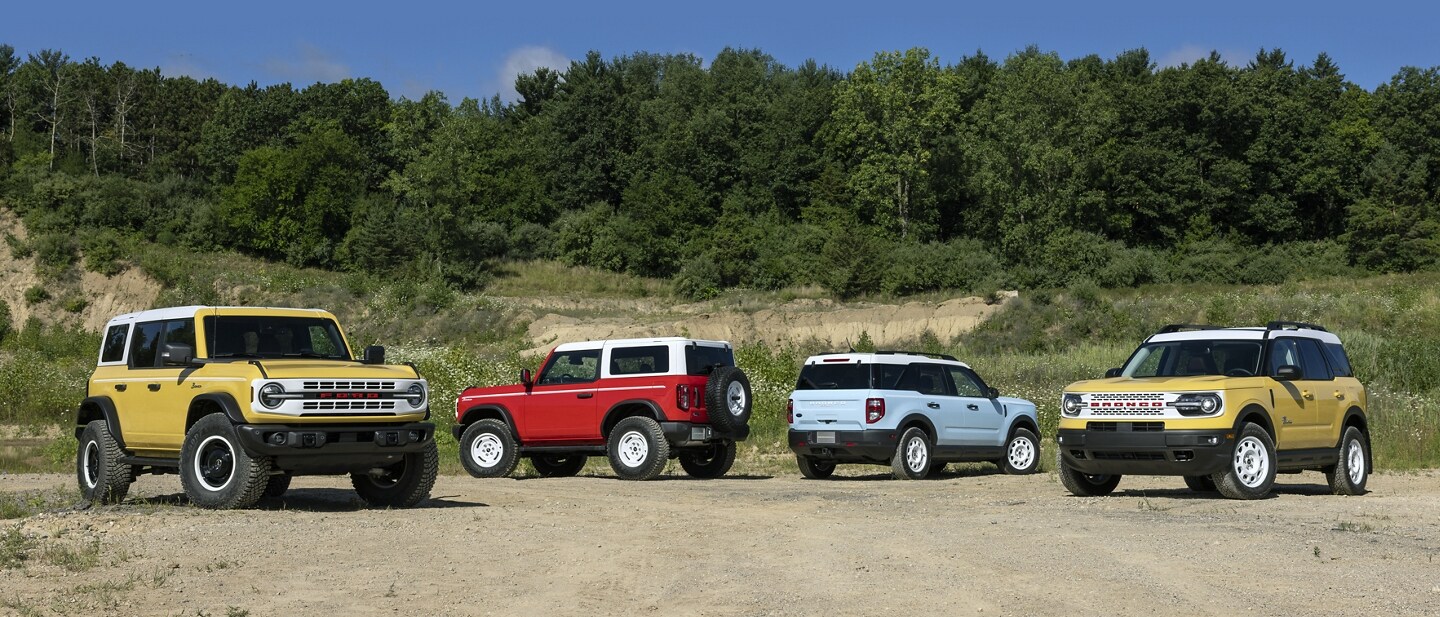 Un grupo de SUV Bronco® y Bronco Sport estacionadas en un camino de tierra.