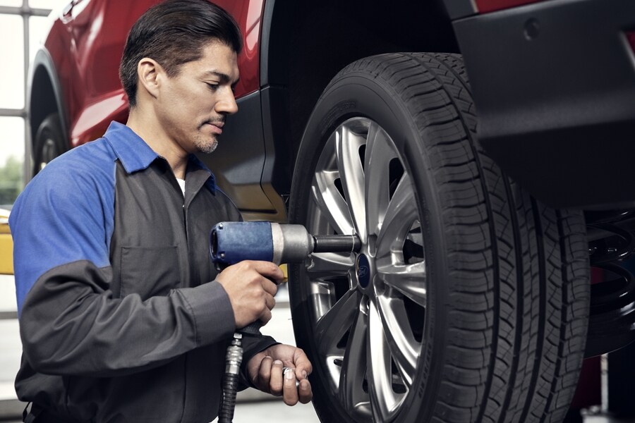 Técnico de un Concesionario Ford cambiando un neumático en un concesionario