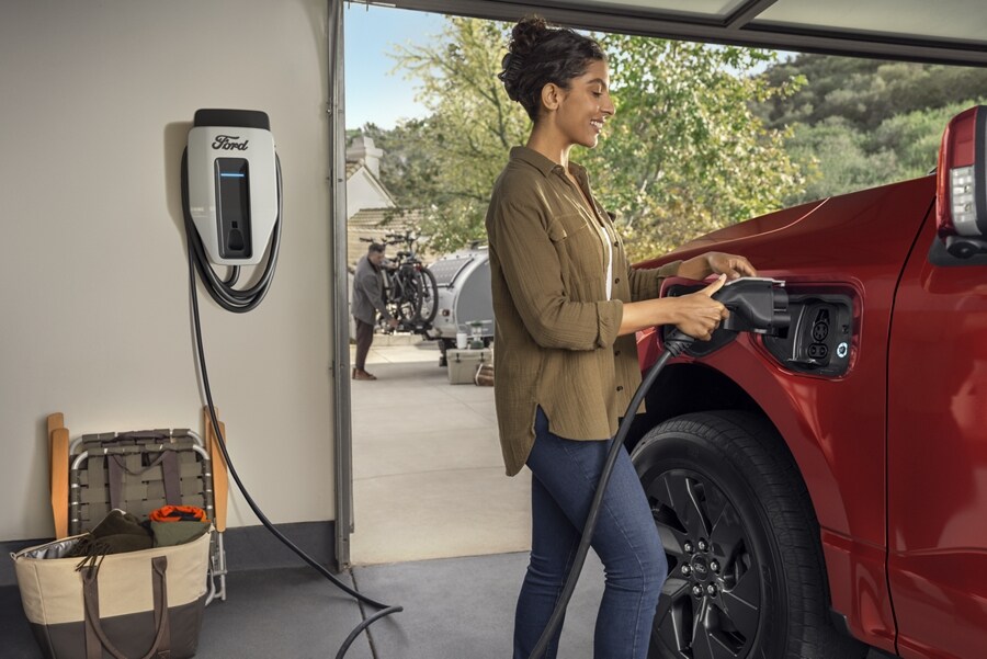 Una mujer comienza a cargar una Ford F-150® Lightning® 2023 en su garaje