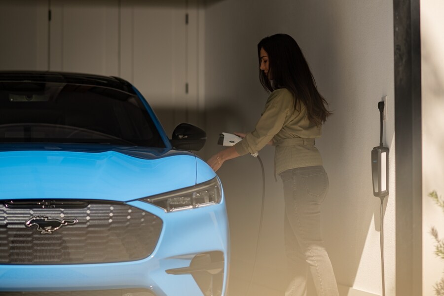 Una mujer comienza a cargar su Ford Mustang® Mach-E® 2023 en su garaje