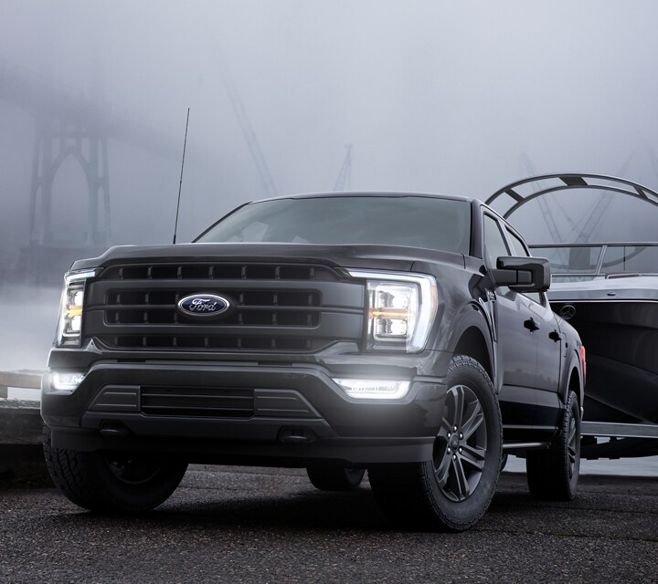 Ford F-150® XLT 2022 en Agate Black ingresando marcha atrás un tráiler para bote en un lago