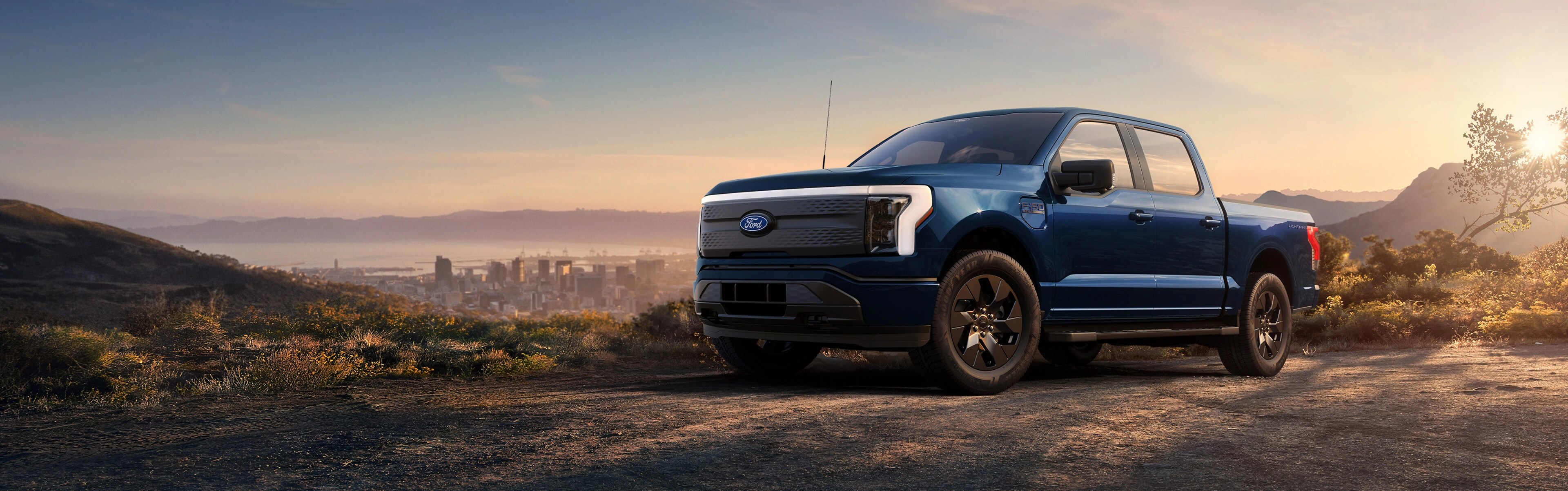 Una camioneta Ford F-150® Lightning® 2025 estacionada en la cima de una colina con vista al horizonte de Long Beach, California