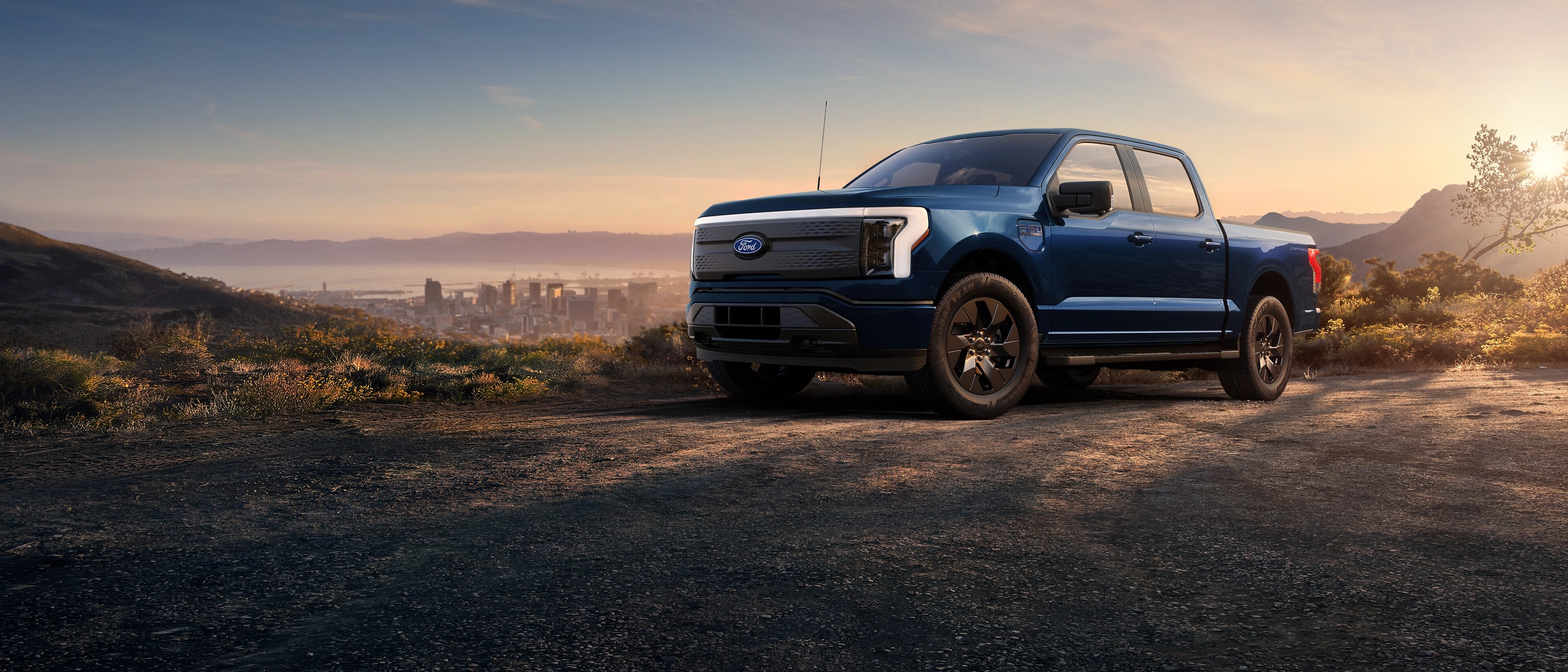Una camioneta Ford F-150® Lightning® 2025 estacionada en la cima de una colina con vista al horizonte de Long Beach, California