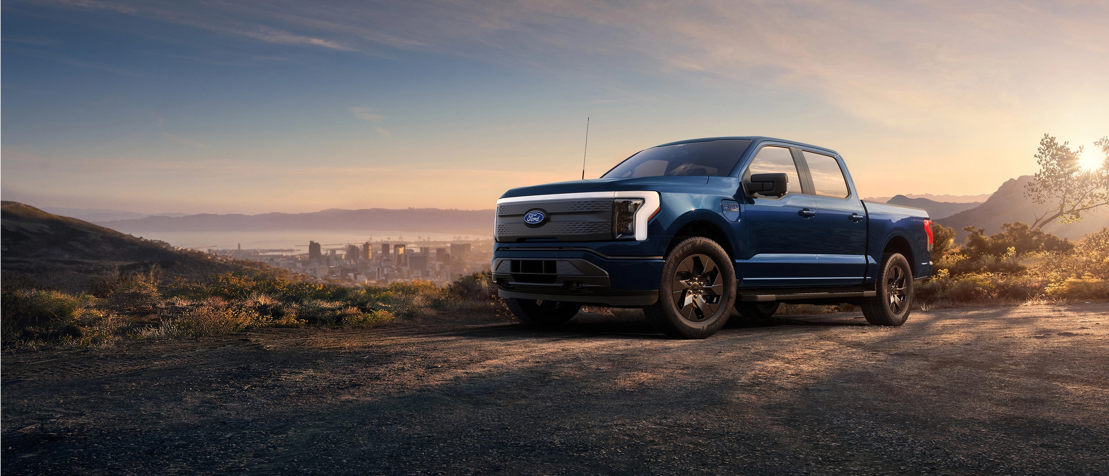 Una camioneta Ford F-150® Lightning® 2025 estacionada en la cima de una colina con vista al horizonte de Long Beach, California