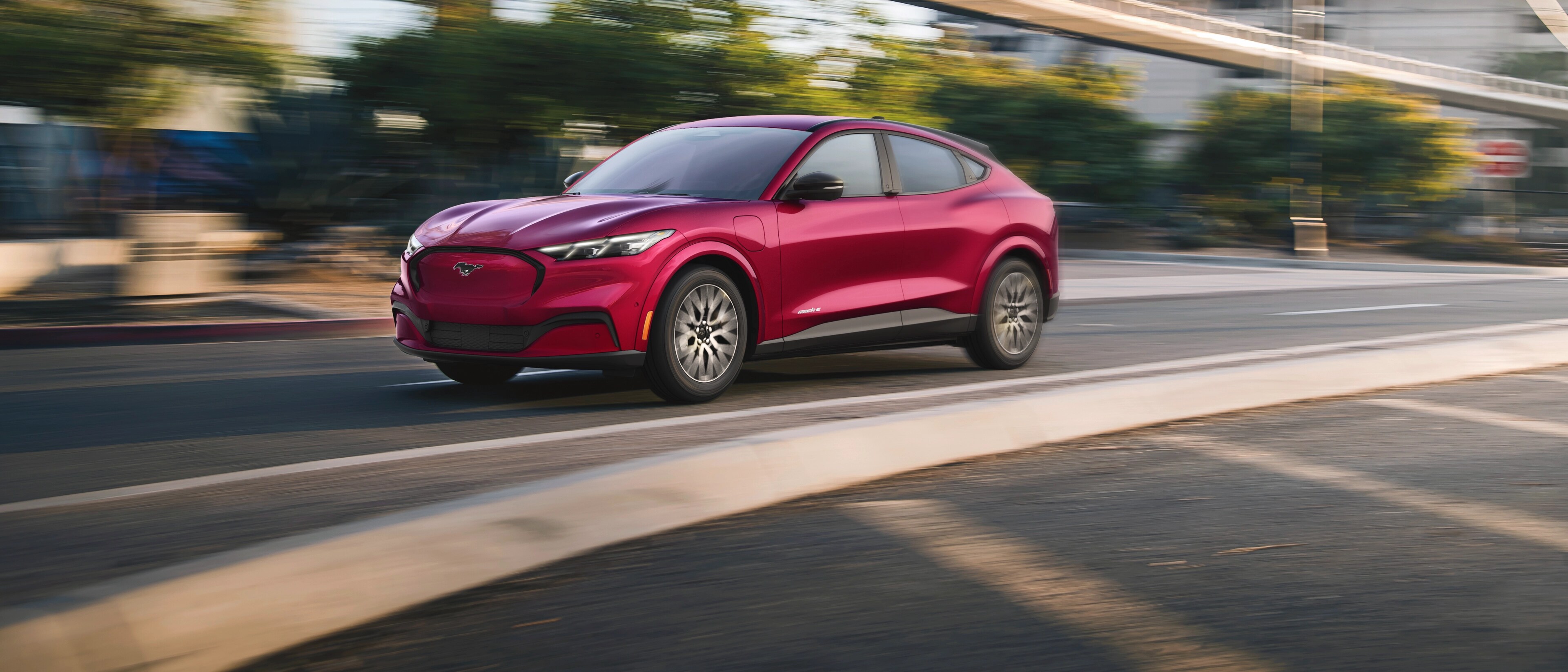 Una Ford Mustang Mach-E® 2025 pasando por una calle urbana