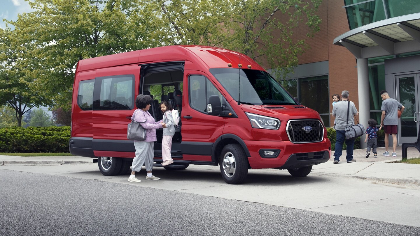 Una mujer ayuda a una joven a salir de una van Ford Transit® 2025