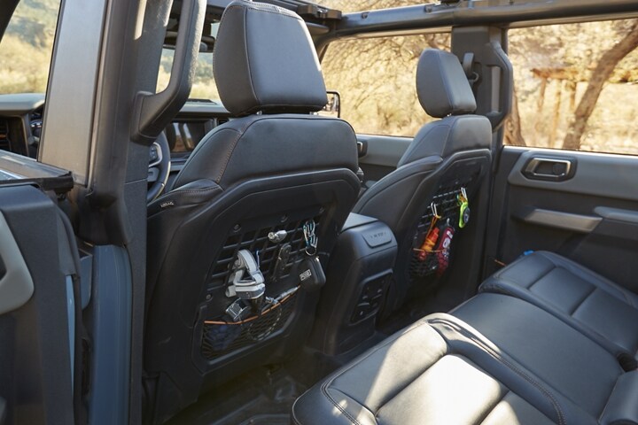 Se muestra el interior de una Ford Bronco® 2024 con asientos delanteros detrás del panel MOLLE