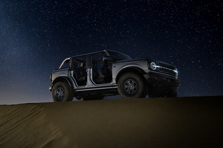 Una Ford Bronco® Badlands® 2024 en Carbonized Gray Metallic estacionada en la naturaleza al atardecer