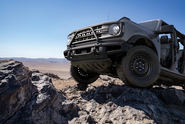 Una Ford Bronco® Black Diamond™ 2024 en Carbonized Gray Metallic circulando por un terreno agreste