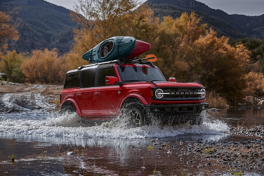 Una SUV Ford Bronco® 2024 de cuatro puertas con soporte para kayak no original Yakima® JayLow montado en el techo