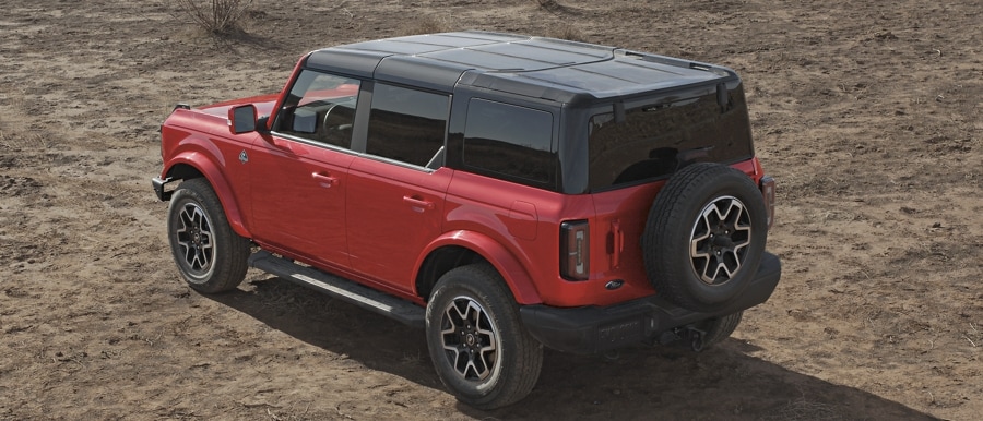 Se muestra el modelo Ford Bronco® Outer Banks® 2024 de cuatro puertas en Race Red con techo duro
