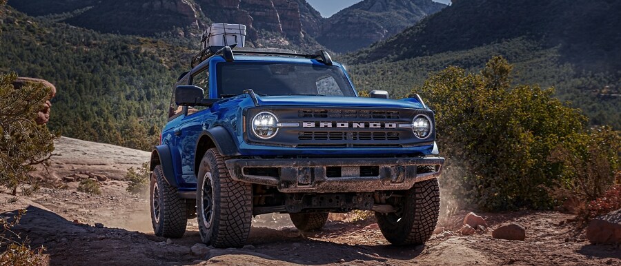 Una Ford Bronco® Black Diamond™ 2024 de dos puertas en Velocity Blue andando por un camino