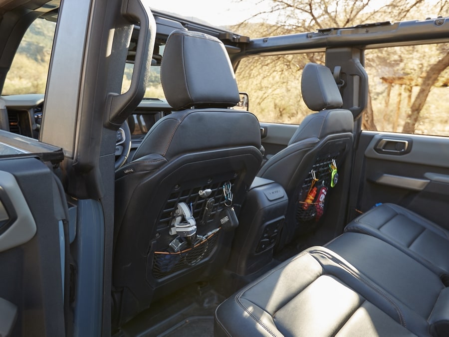 Interior de una Ford Bronco® 2024 que muestra los bolsillos MOLLE en la parte trasera de los asientos delanteros
