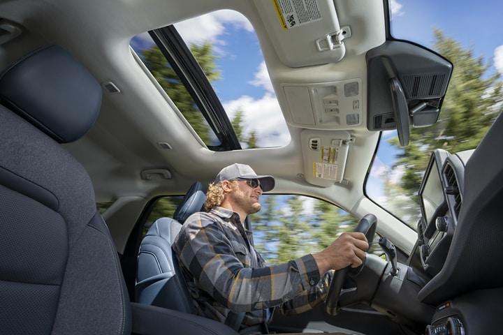 Un hombre conduce una SUV Ford Bronco® Sport 2023 con el techo corredizo abierto