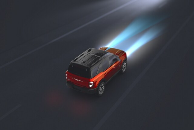Vista superior de la SUV Ford Bronco® Sport 2023 andando por la oscuridad con los Faros Delanteros con Luces Altas Automáticas que iluminan el camino