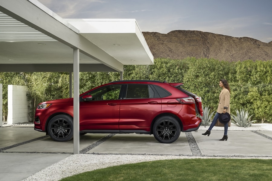 Una mujer con dos bolsos activa la puerta trasera levadiza manos libres de una Ford Edge® 2024