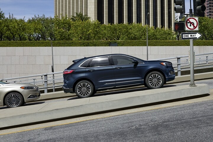 Una SUV Ford Edge® Titanium Elite 2024 en Stone Blue estacionada en una pendiente