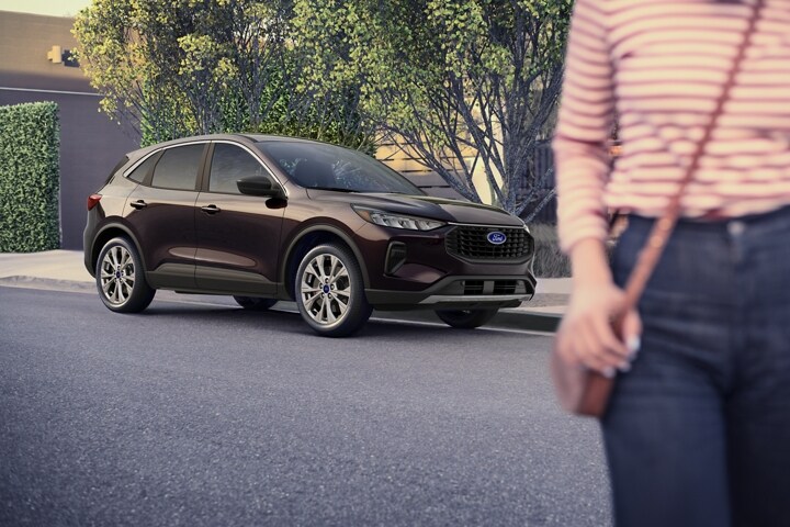 Una Ford Escape® 2023 en Cinnabar Red estacionada en una calle junto a una casa