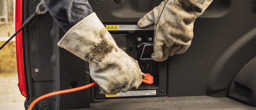 Primer plano de un trabajador enchufando un cable eléctrico en la característica Pro Power Onboard
