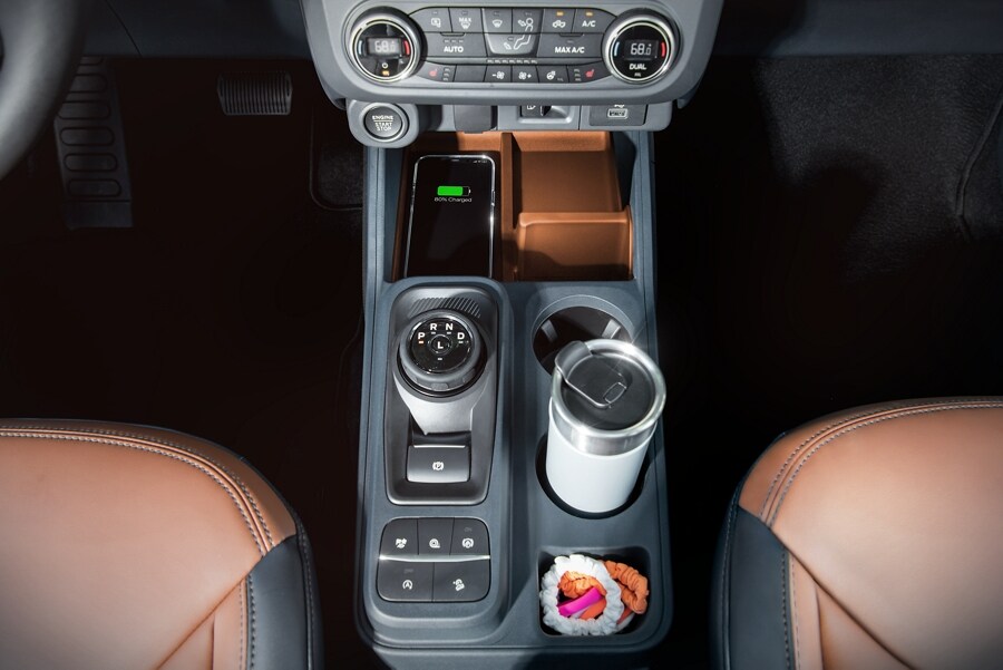 Vista de las opciones de organización de la consola de la Ford Maverick® 2023 con portavasos, teléfono y dial giratorio en la palanca de cambios