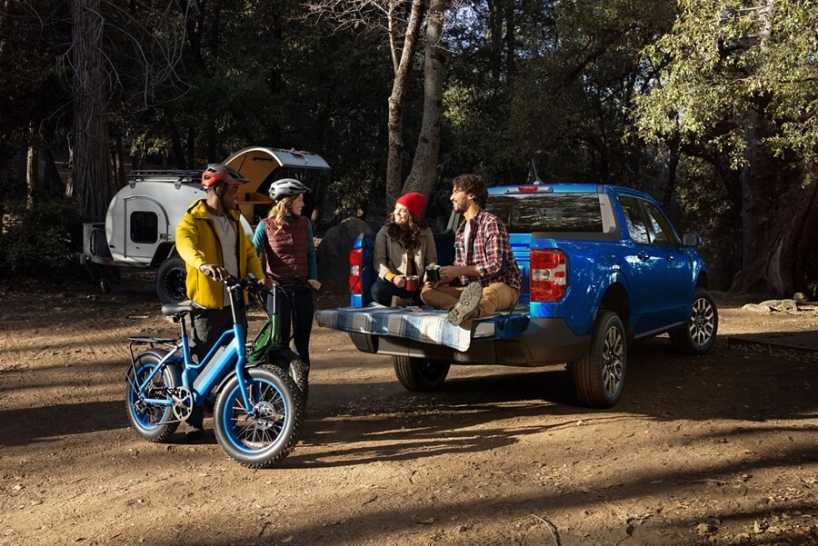 Pareja sentada en la puerta trasera de un modelo Ford Maverick® LARIAT 2023