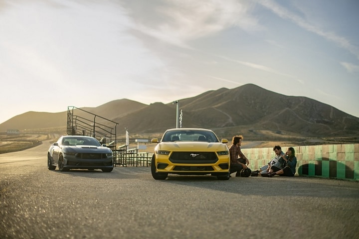 Una Ford Mustang® EcoBoost® cupé 2024 en Yellow Splash Metallic Tri-coat estacionada cerca de un grupo de gente