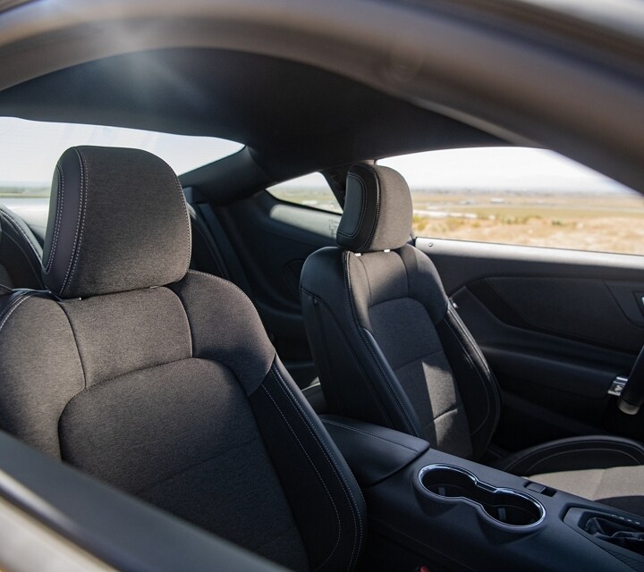 Se muestran los asientos delanteros del Ford Mustang® 2024 a través de la ventana del lado del pasajero