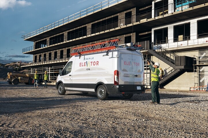 Vista trasera de tres cuartos de la van Transit® en un sitio de construcción
