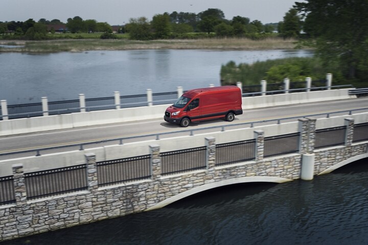 Una van Ford Transit® 2023 en Race Red circulando por un puente