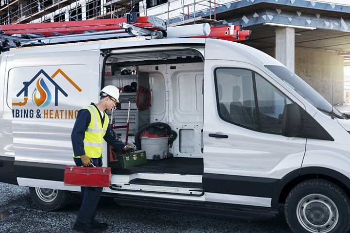 Un trabajador cargando equipos en una Transit® Cargo van estacionada